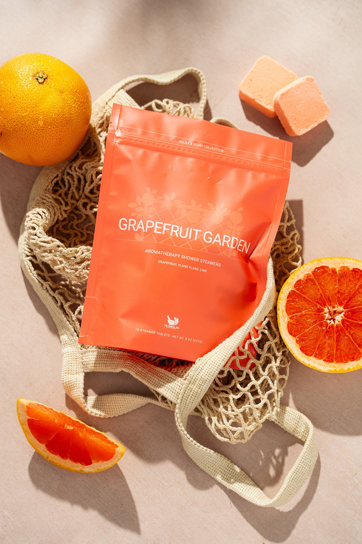 Grapefruit Garden product package on a textured surface with grapefruit slices and an orange.